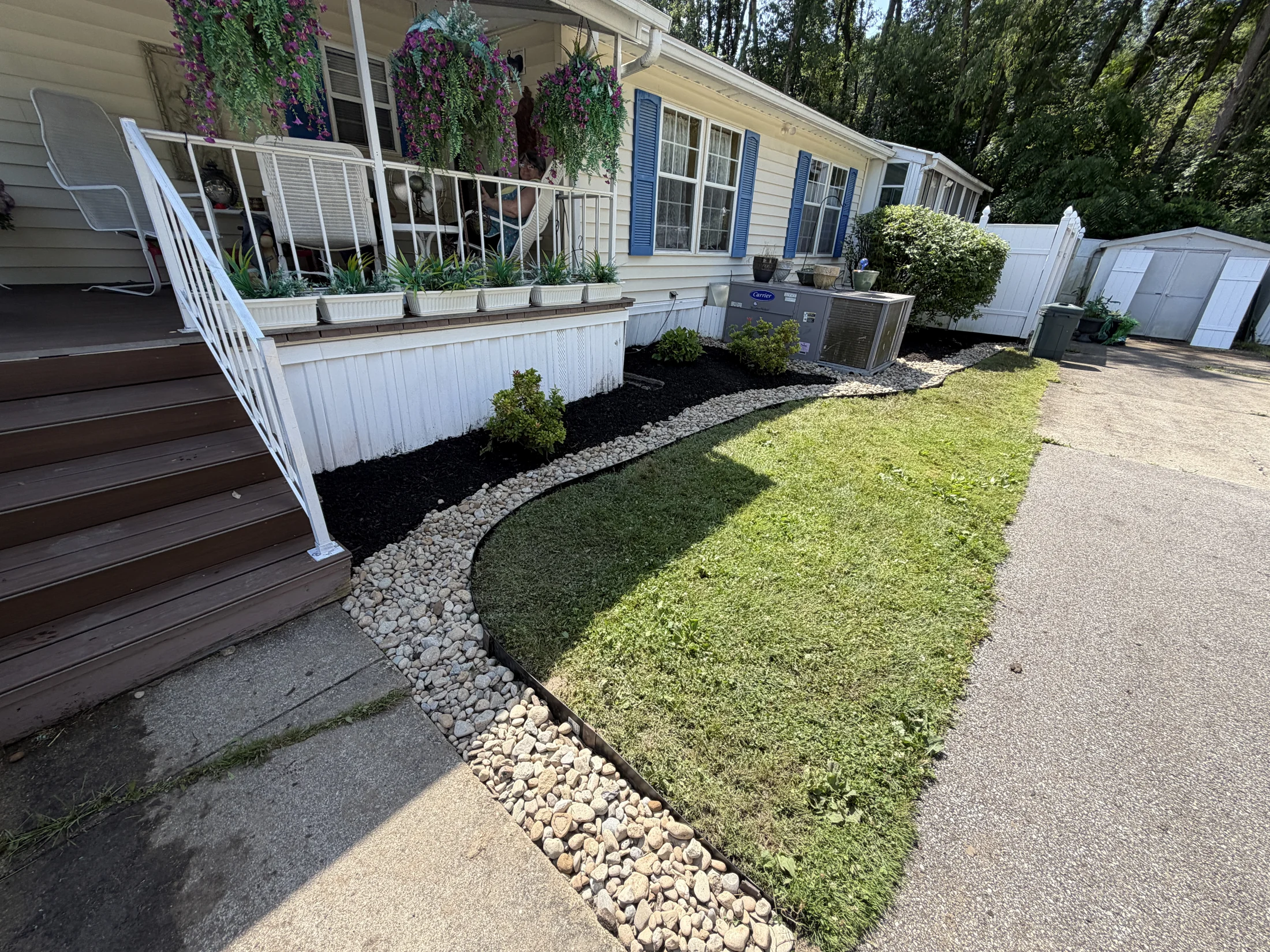 Fresh mulch and curved stone edging beside the front porch