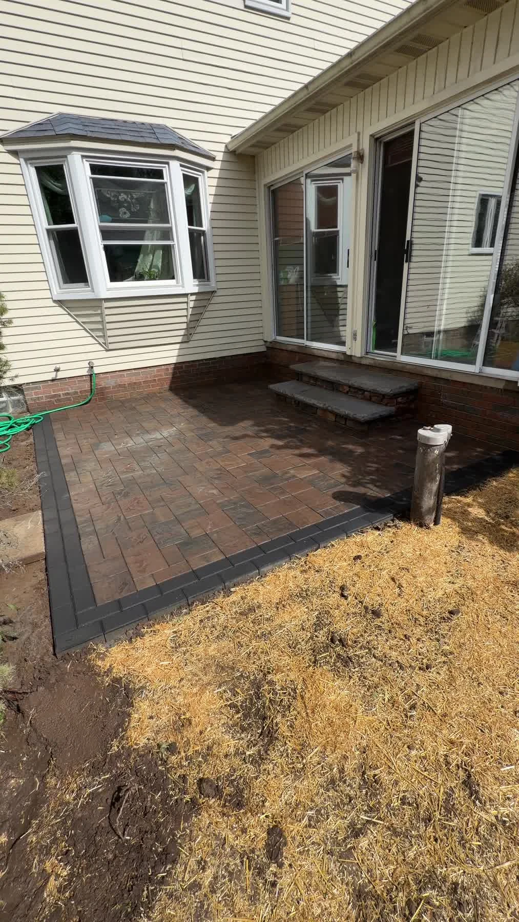 Completed paver patio beside a home